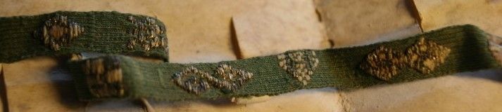 Lacet de tricot vert brodé de 13 motifs différents en fils or, argent, vert foncé, écru et rose, partie du vêtement de Robert II, duc de Bourgogne (1272-1306), ou de son épouse Agnès de France (1260-1325), fille de Louis IX (1285, H 285 12).